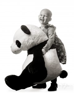 Photo of a girl holding a large panda bear doll